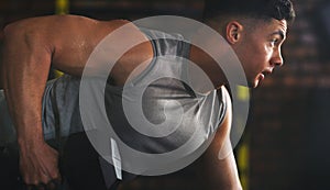 Your muscles will grow with each rep. a sporty young man exercising with a dumbbell at the gym.