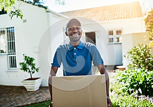 Your package is in safe hands. Portrait of a young delivery man carrying a package during a delivery.