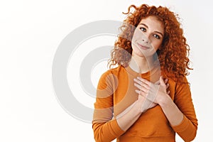 Your pleasant gift hit girls heart. Sensual gentle and tender curly-haired redhead woman hold hands on chest, tilt head