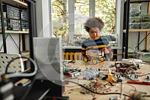 Your potential. Boy using screwdriver while fixing bolts on a robot vehicle. Smart kids and STEM education.