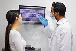 Your x-rays seem to be normal. a dentist discussing the results of a patients teeth x ray.