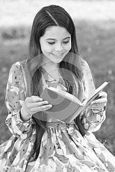 For your reading pleasure. Happy girl read book in summer park. Small child enjoy reading outdoors. Summer reading list