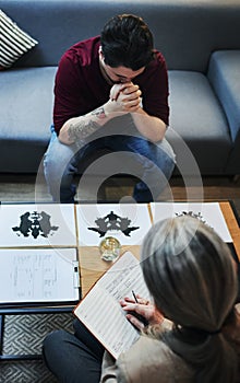 Your subconscious mind has something to say. a psychologist conducting an inkblot test with her patient during a