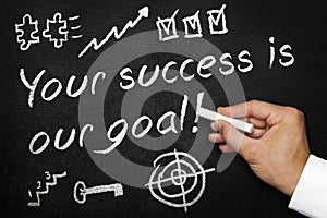 Your success is our goal. Blackboard or chalkboard with hand and chalk. photo