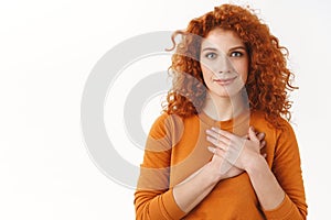 Your support mean a lot. Touched tender gorgeous redhead woman with blue eyes, curly haircut, press hands to heart