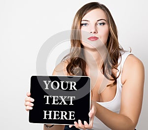 Your text here written on virtual screen. beautiful woman with bare shoulders holding pc tablet. technology, internet