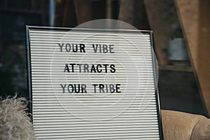 Your vibe attracts your tribe motivational quote on a board