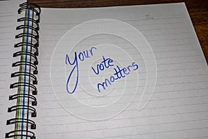 Your vote matters, handwriting  text on paper, political message. Political text on office agenda. Concept of democracy, voting,