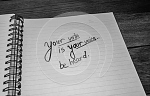 Your vote is your voice, handwriting  text on paper, political message. Political text on office agenda. Concept of democracy,