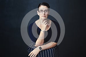 Your will to conquer trumps all adversity. Studio portrait of a corporate businesswoman posing against a dark background photo