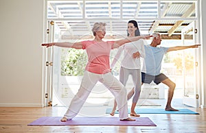 Youre doing great. Full length shot of a female yoga instructor working with a senior couple.