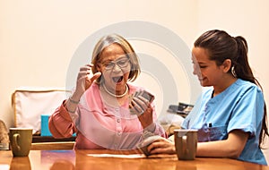 Youre playing against someone wiser. a senior woman playing cards with her caregiver.