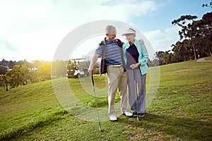 Youre up. a smiling senior couple enjoying a day on the golf course.