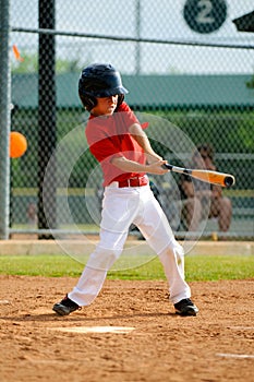 Youth baseball player swinging bat