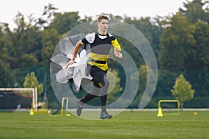 Youth Football Player Running with Parachute. Soccer Football Endurance Training photo