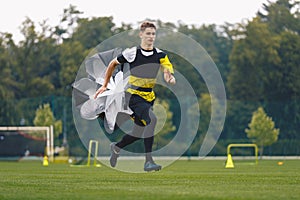 Youth Football Player Running with Parachute. Soccer Football Endurance Training