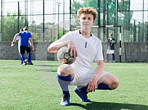 Youth football player sitting on field