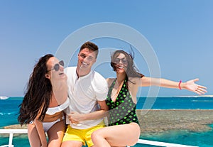 Youth having fun and standing on the yacht at a sunny summer day