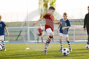 Youth Junior Athletes in Red and Blue Soccer Shirts. Two Boys Compete for the Ball
