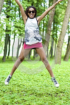 Youth Lifestyle Concepts. African American Teenager Girl with Nice Dreadlocks Jumping with Positive Expression