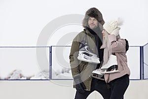 Youth Lifestyle. Young Loving  Caucasian Couple On Skatingrink With Ice Skates Posing Together Embraced Over a Snowy Winter