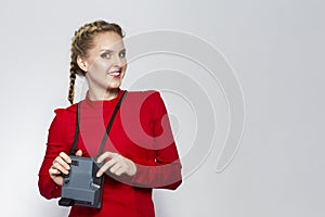 Youth Lifestyles. Posiitve Caucasian Blond Girl Posing With Old School instant Camera in Red Dress