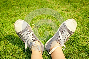 Youth sneakers on girl legs on grass