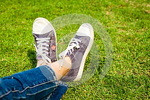 Youth sneakers on girl legs on grass