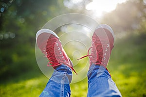 Youth sneakers on girl legs on grass