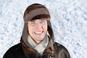 Youth stands in ear-flaps hat