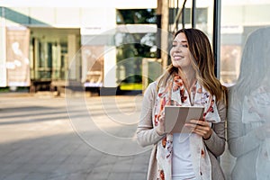 Youth and technology. Attractive young business woman using tablet computer outdoors.