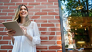 Youth and technology. Attractive young business woman using tablet computer outdoors.