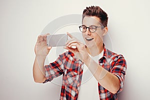 Youth and technology. Studio portrait of man using smart phone. Isolated