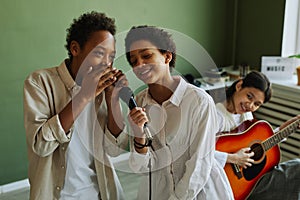 Youthful African American schoolchildren performing song during repetition