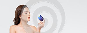 Youthful beautiful Asian woman showing credit card on banner background