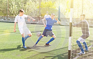 Youthful football players challenging for ball