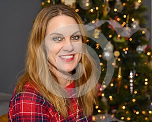 Youthful forty-seven yearold redheaded woman posing in front of her Christmas tree in her home in Saint Louis, Missouri. photo