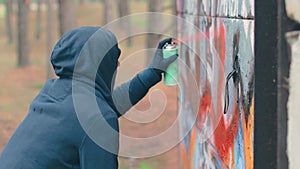 Youthful Guy Drawing Graffiti Using Spray Paint Can