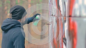 Youthful Guy Drawing Graffiti Using Spray Paint Can