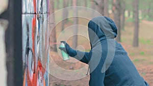 Youthful Guy Drawing Graffiti Using Spray Paint Can