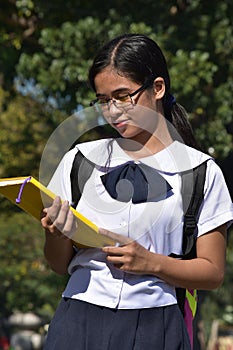 Youthful Minority Female Student Reading With Notebooks