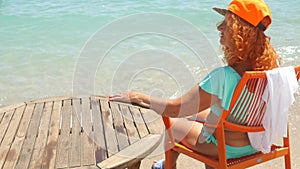 Youthful old woman in blue bikini relaxing by the sea