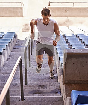Youve got to push hard to win. Shot of an athlete running up a flight of stairs as part of his training.