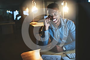 Youve gotta do what youve gotta do. a handsome young businessman making a phonecall while working late at night in a