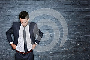 Youve gotta look the part. a businessman adjusting his pants against a grey wall.