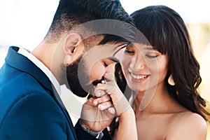 Youve made me the happiest man on earth. an affectionate young bridegroom kissing his brides hand while standing