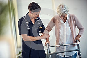 Youve walked so far already. a young female nurse assisting a senior woman walk using a walker in a nursing home.