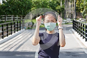 The ypung woman in medical protective mask relaxing in the park.  campaign to use protective mask from COVID19