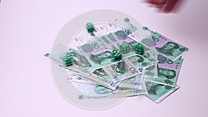 Yuan Chinese currency and dice isolated on a white background. Studio footage, non edited.