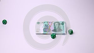 Yuan Chinese currency and dice isolated on a white background. Studio footage, non edited.